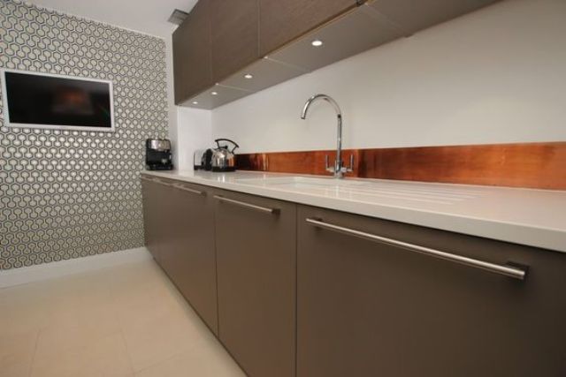 Warm Copper Backsplash Adds Richness to Sleek Kitchen