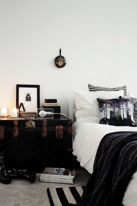 Utilize a Black Trunk with Vintage Hardware for Bedside Storage
