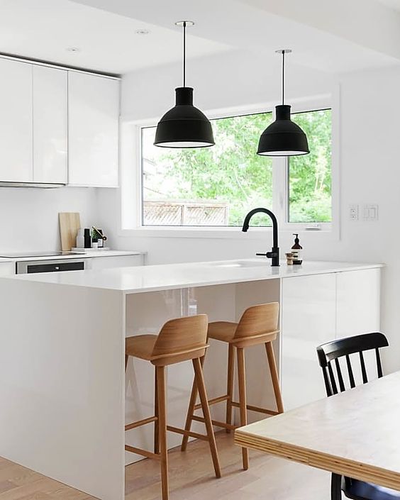 Black Bell Pendants Add Contrast Over Island Seating