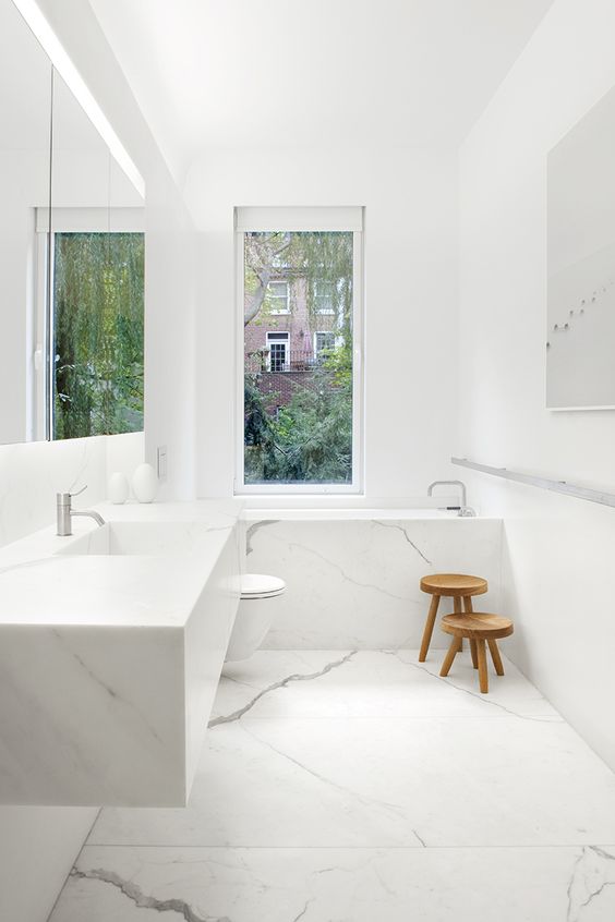 Wooden Stools Add Natural Texture to Marble Bath