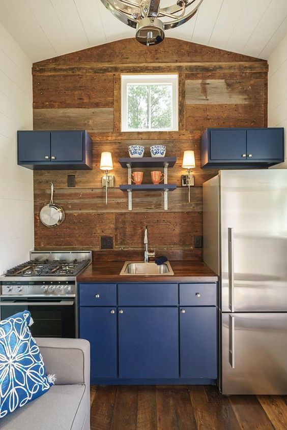 Deep Blue Cabinets Contrast with Rustic Wood Walls