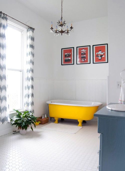 Bright Yellow Claw-Foot Tub Anchors a White Bathroom
