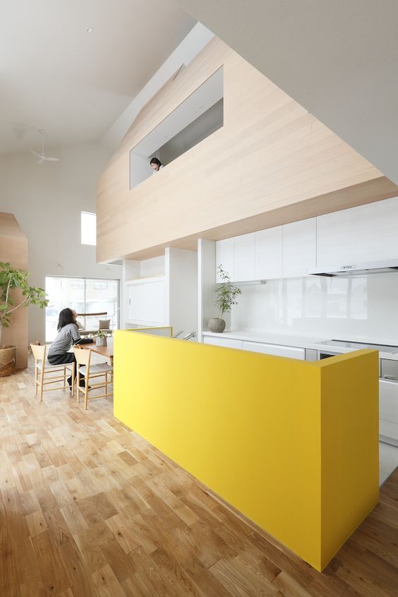 Bold Yellow Island Divides Kitchen and Dining Areas