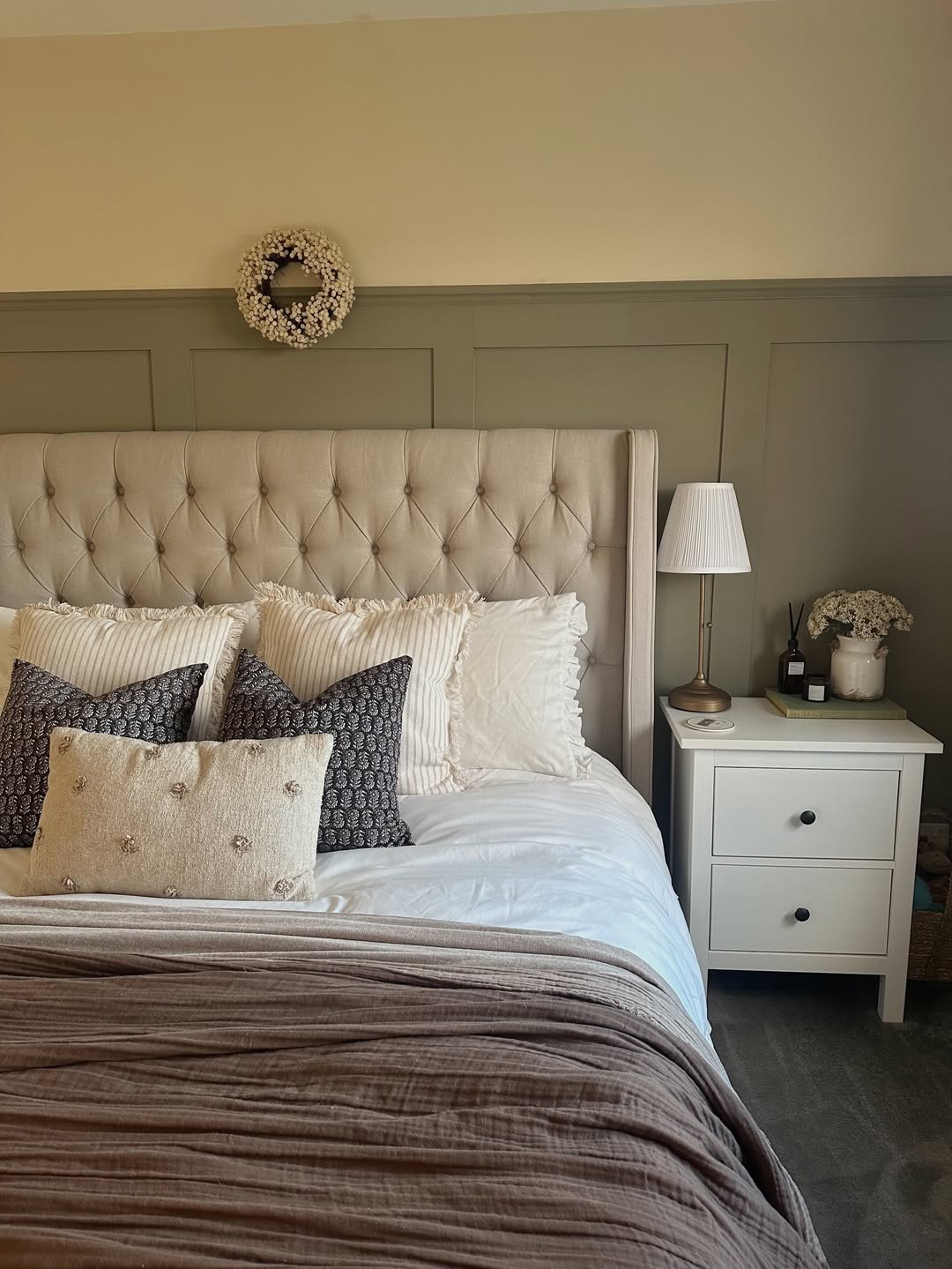 Small White Wreath Adds a Delicate Touch Above the Bed