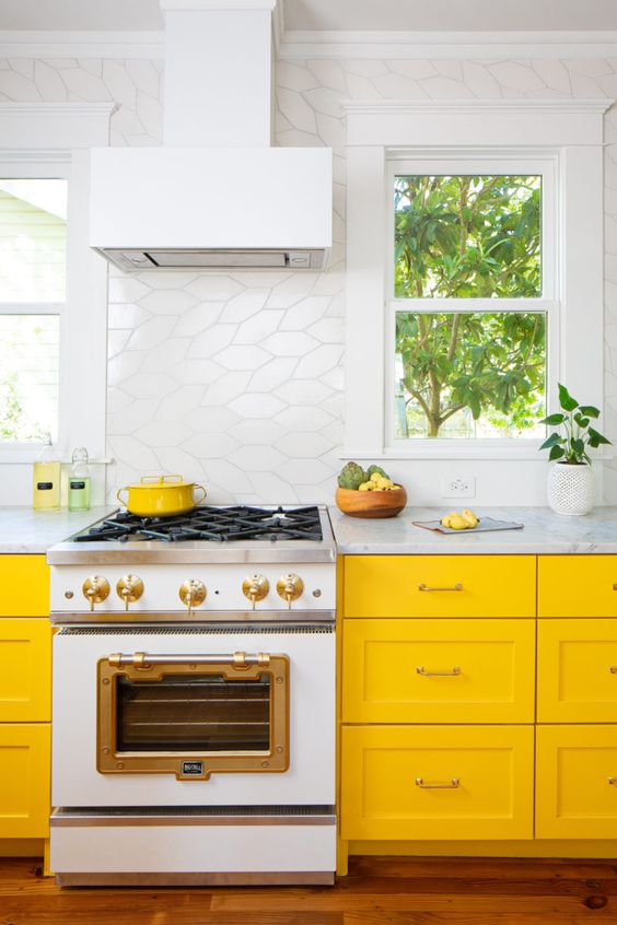 White Range with Brass Accents Complements Yellow Cabinets