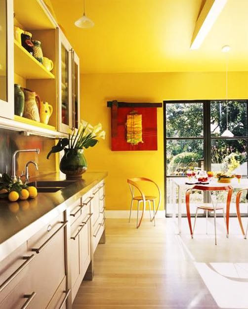 Orange Chairs Add Playful Contrast to Yellow Kitchen Walls