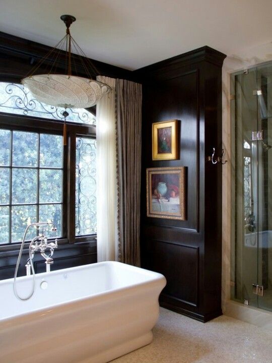 Traditional Paintings Add Warmth Above Dark Wood Paneling
