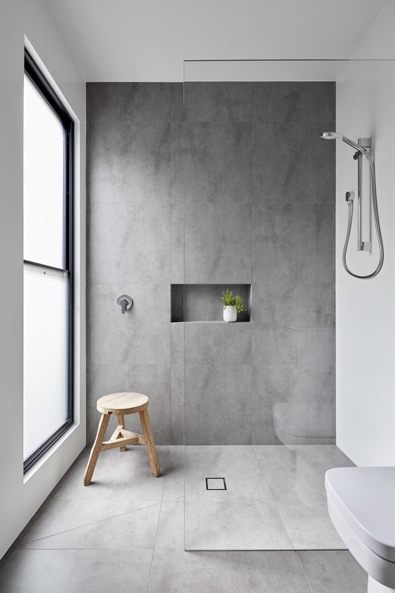 Wooden Stool Adds Natural Warmth to a Grey Tiled Shower
