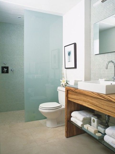 Wood Vanity With Glass Shelves Displays Soaps and Towels