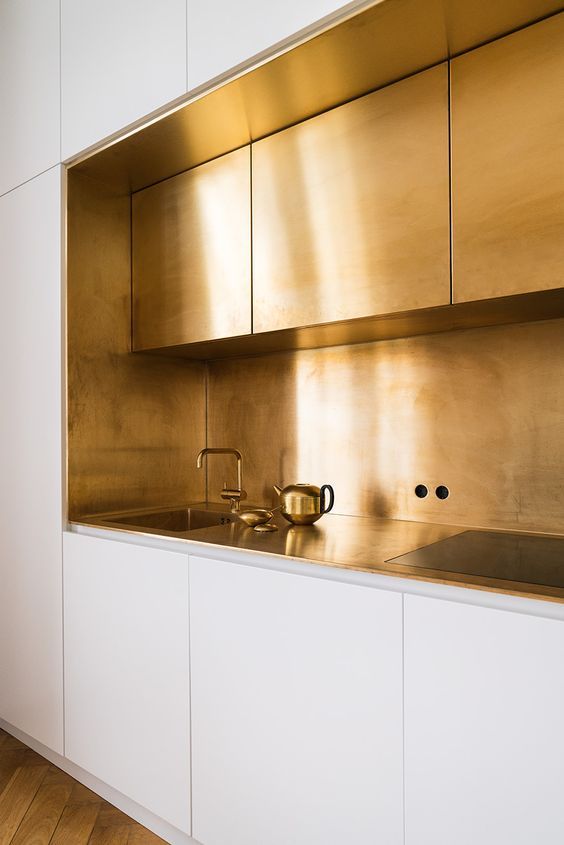 Gold Backsplash and Cabinetry Creates a Dramatic Statement