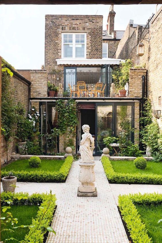 Anchor a Formal Garden Path with a Stone Pedestal Statue