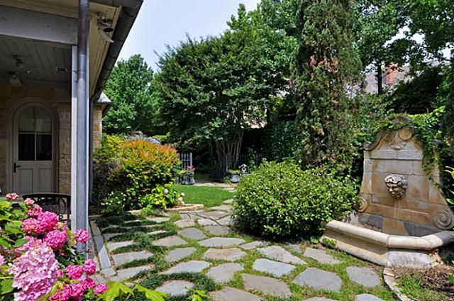 Stone Fountain With A Carved Face Adds A Classical Touch