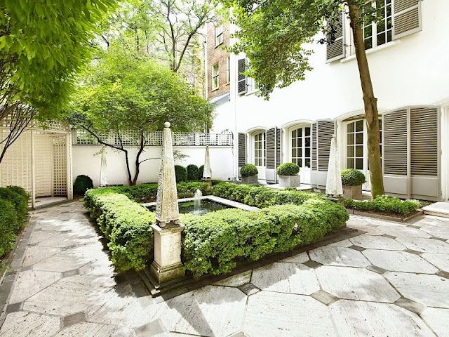Stone Obelisks Add Vertical Interest To A Formal Courtyard