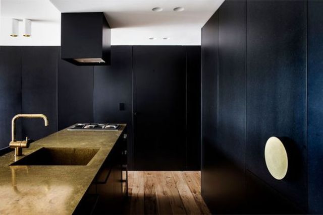 Brass Countertops and Range Hood Add Warmth to Dark Kitchen