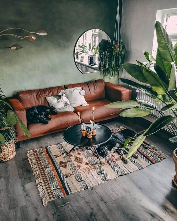 Round Mirror Reflects Greenery and Light Above Sofa