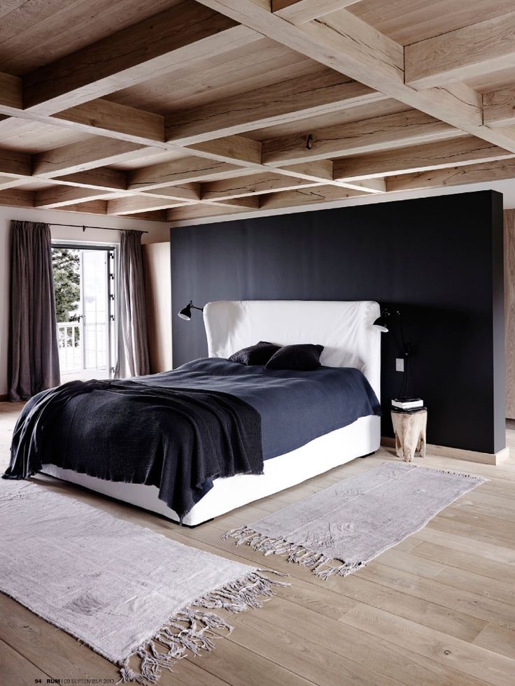 Dark Accent Wall Creates a Dramatic Backdrop for the Bed