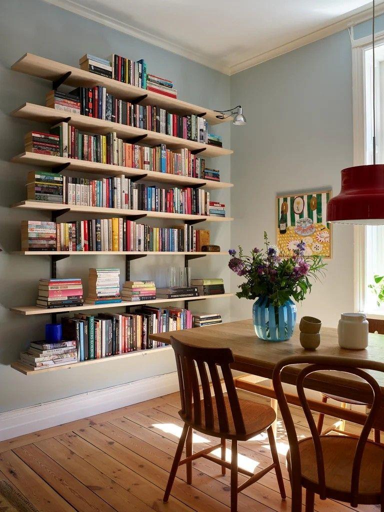Light Wood Floating Shelves Display Books Above Dining Area