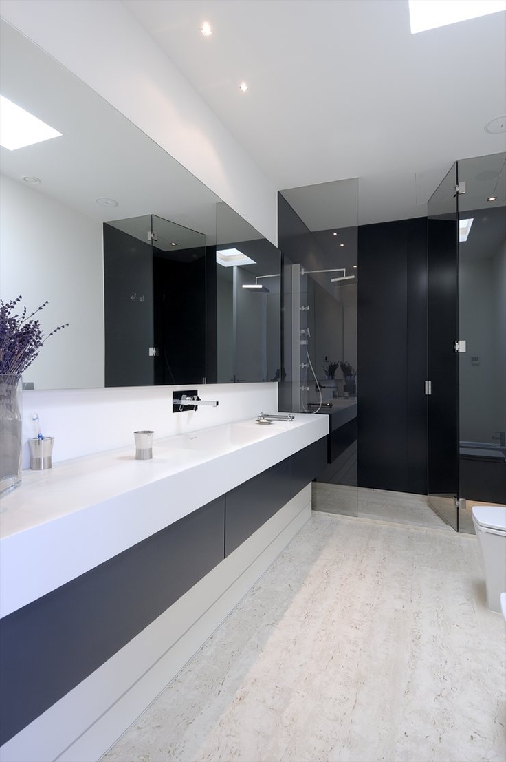 Dark Base Cabinetry Grounds a Floating White Vanity