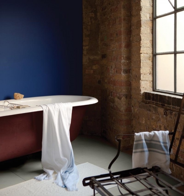 Deep Red Bathtub Creates a Bold Statement Against Blue Wall