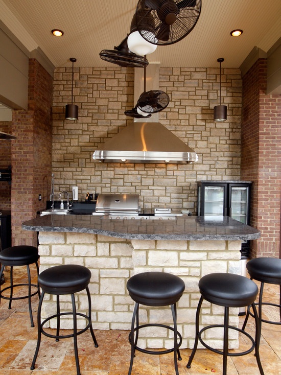 Outdoor Kitchen With Stacked Stone Bar And Stainless Steel Appliances
