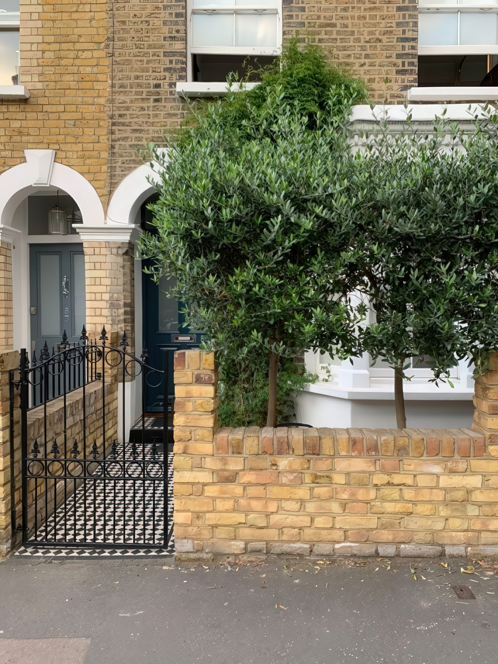 Low Brick Walls Soften Entryway With Olive Trees