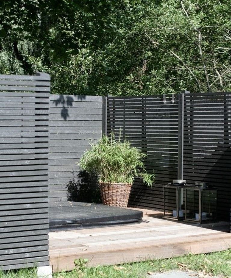 Dark Slatted Fence Sections Create Cozy Outdoor Nooks