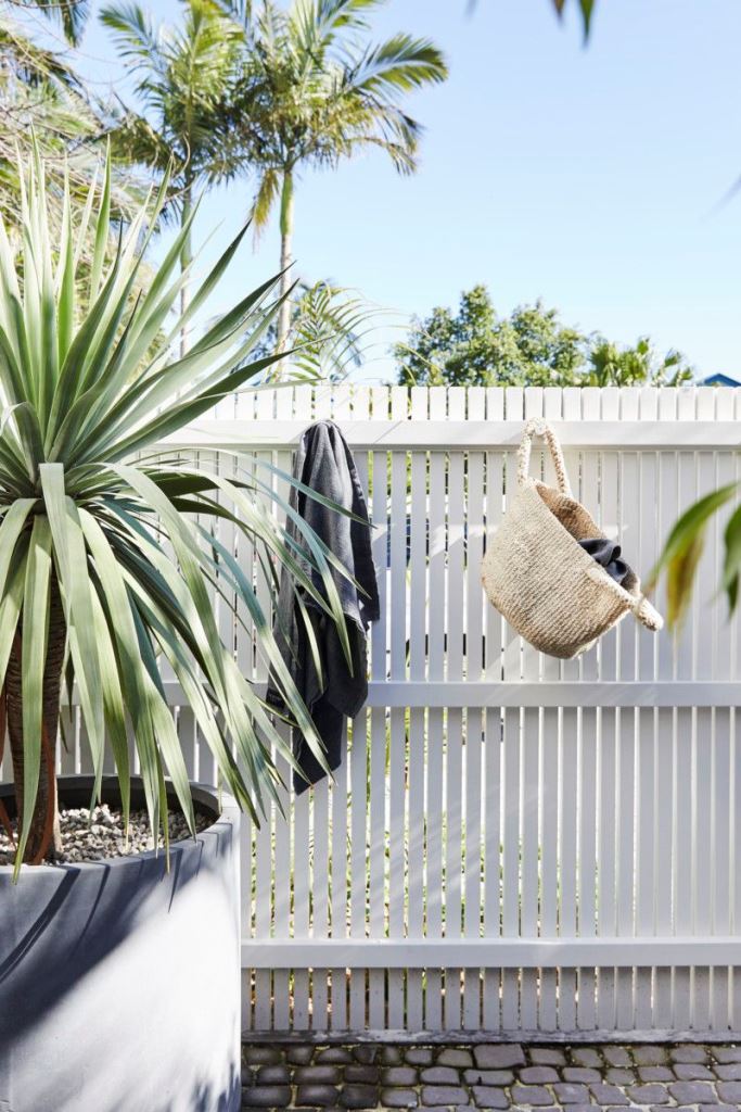 Jute Basket Adds Casual Storage To A White Slatted Fence